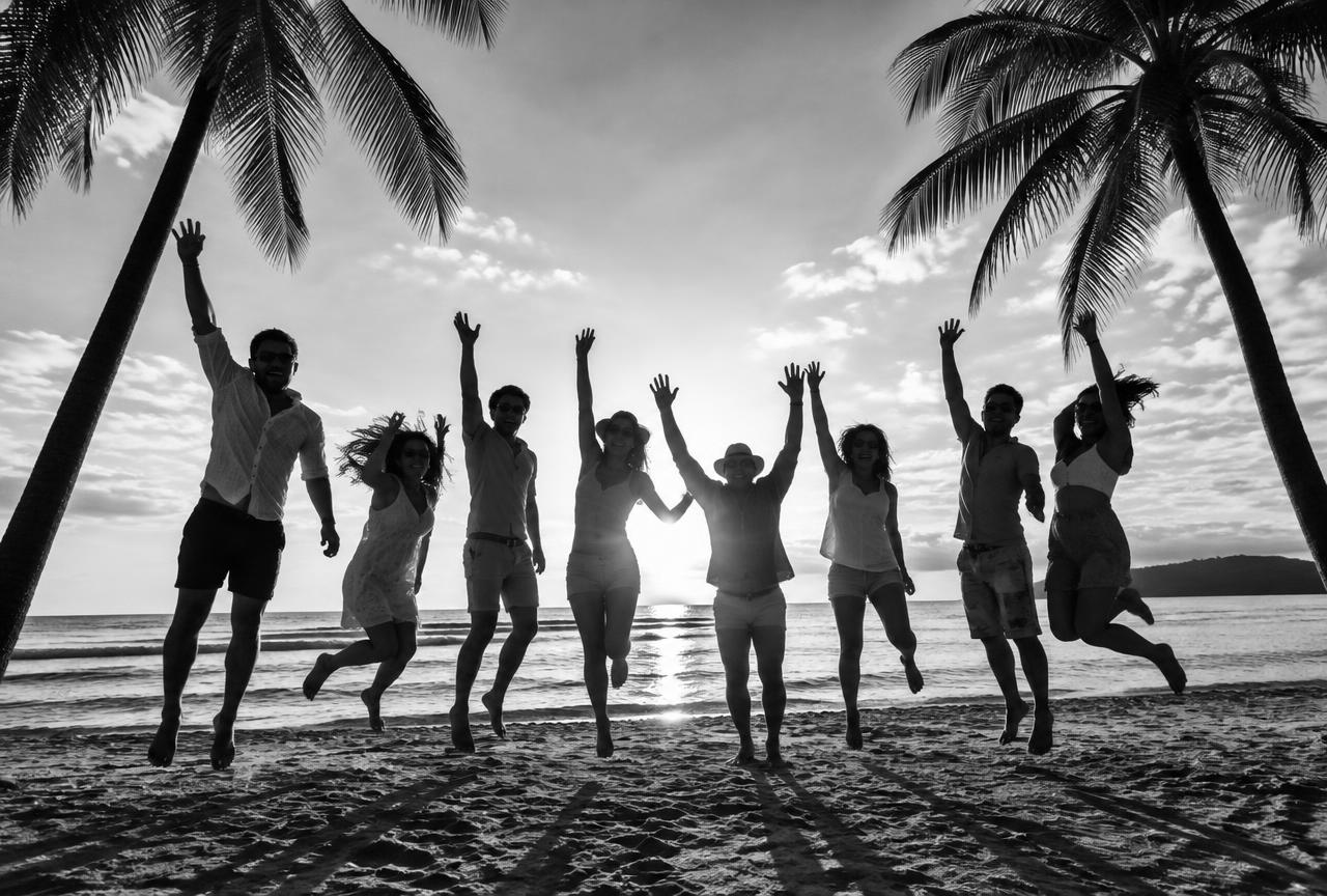 Incentive trip group jumping on the beach at sunset